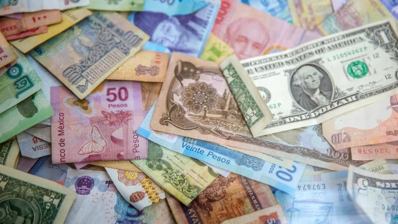 Billets et monnaie ouest-africains sur une table avec fond sombre